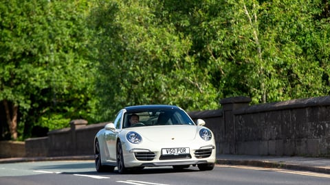 White Porsche 911 Carrera driving